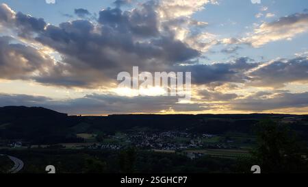 Sunset View Over a Scenic Village With Dramatic Clouds and Rolling Hills Stock Photo