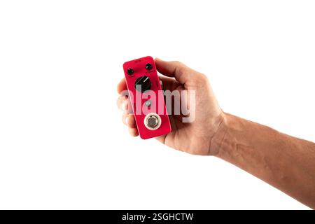 Male hand holding a pink guitar effects pedal isolated on white background cutout Stock Photo