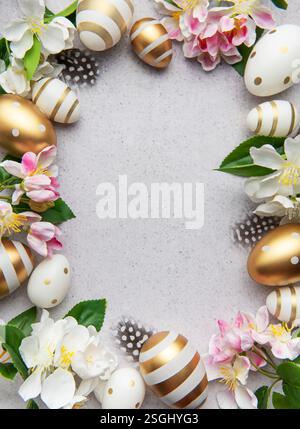 Golden eggs and flowers create a festive easter border on a light background Stock Photo