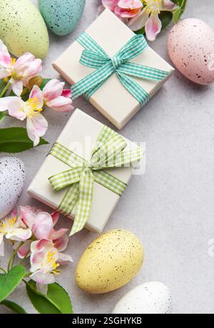 Pastel eggs and gift boxes with flowers on a light background Stock Photo