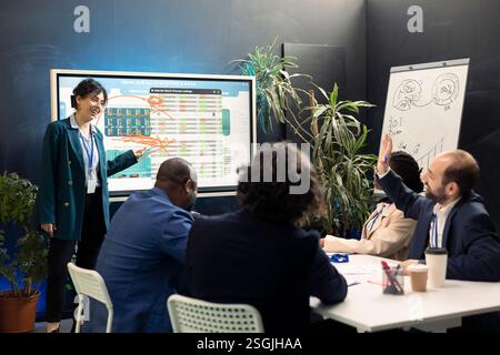Team of company experts reviews feedback on sales and orders to work on future projects, developing marketing strategies in conference room. Startup enterprise managers in meeting. Stock Photo