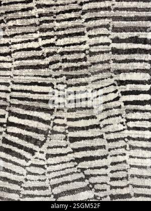Close up of carpet rug fabric in snake scale pattern, or in random horizontal stripes pattern. In black and white color, monochrome concept. Seamless Stock Photo