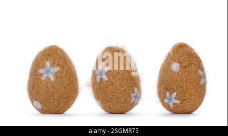 Three easter eggs decorated with small white and light blue flowers. Standing, isolated on a white background Stock Photo