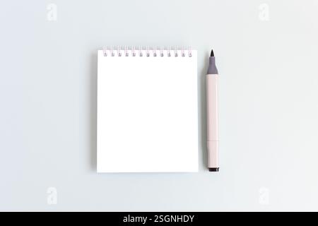 Clean notepad mockup and felt tip pen on a blue background. Empty notebook template. Stock Photo
