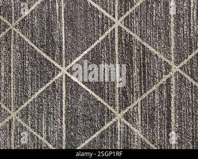Close up carpet rug texture in random diamond and triangle pattern with black vertical stripe. Carpet rug fabric seamless background texture. Stock Photo