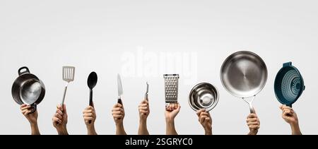Multiple hands holding various kitchen utensils Stock Photo