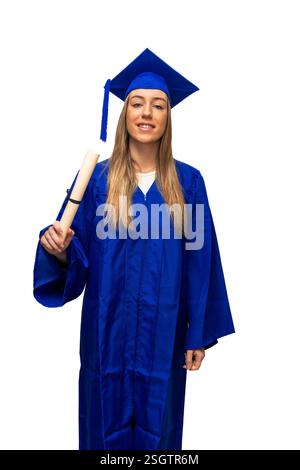 Young graduate wearing a blue gown and cap, proudly holding a diploma while smiling against a white background, celebrating the achievement of college Stock Photo
