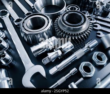 Variety of automotive tools laid out on a black surface for mechanical repairs and maintenance tasks in a workshop Stock Photo