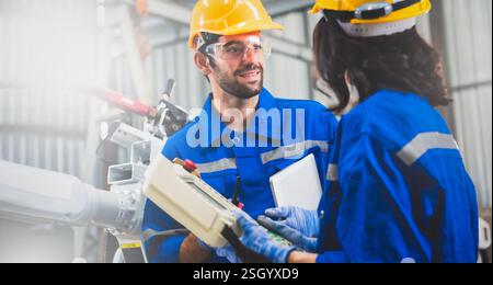 Engineers mechanic using computer controller Robotic arm for welding steel in steel factory workshop. Industry robot programming software for automate Stock Photo
