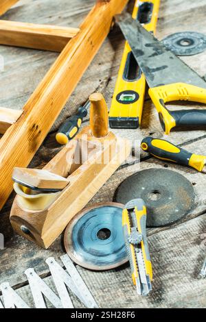 Workspace filled with various hand tools and woodworking equipment on rustic wooden surface Stock Photo
