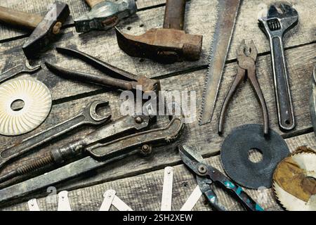 Assorted hand tools displayed on rustic wooden surface in workshop setting during daylight hours Stock Photo