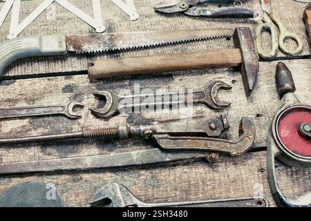 Assorted hand tools displayed on rustic wooden surface in workshop setting during daylight hours Stock Photo