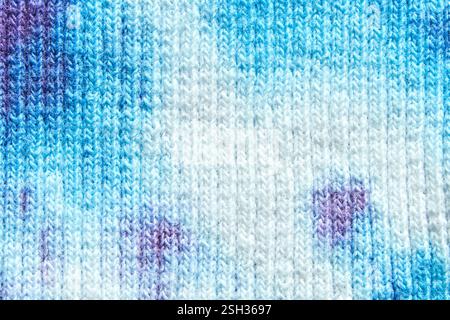 Abstract blue and white textile pattern with purple accents close up. Stock Photo