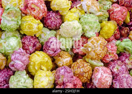 Lots of colorful caramelized sweet popcorn, close up shot, abstract food background Stock Photo