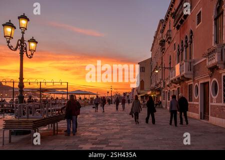 Red blood sky sunset over Venice Lagoon with Salute Basilica domes and ...