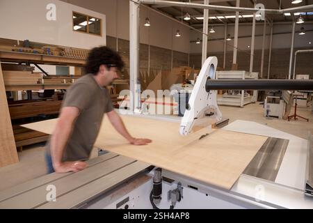 Man Operating a Table Saw for Woodwork in Carpentry Workshop Stock Photo