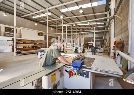 Man Operating a Table Saw for Woodwork in Carpentry Workshop Stock Photo