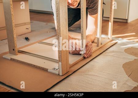 Man assembling furniture at home for a DIY project, selective focus Stock Photo