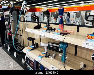Kyiv, Ukraine - February 09, 2025: Variety of handheld and standing garment steamers displayed on shelves in a store Stock Photo