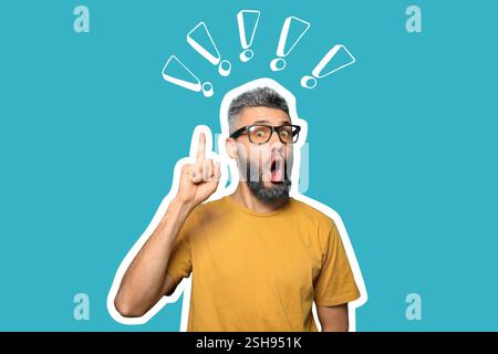Emotional man with raised index finger and exclamation marks on blue background Stock Photo