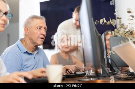 Old man learning computer programs in training room Stock Photo