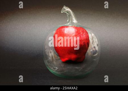 Apple in a glass apple: photo with increased depth of field with reflections of the surroundings on dark background. Stock Photo