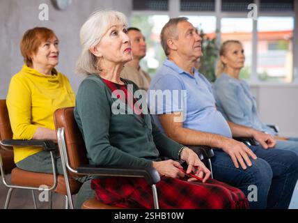 Group of older students sitting and listening at lesson Stock Photo