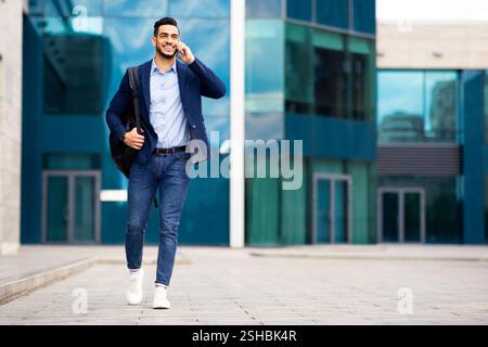 Young middle-eastern entrepreneur going home, talking on phone Stock Photo