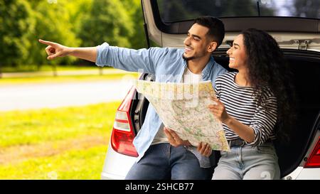 Excited guy traveller showing his girlfriend something aside, copy space Stock Photo