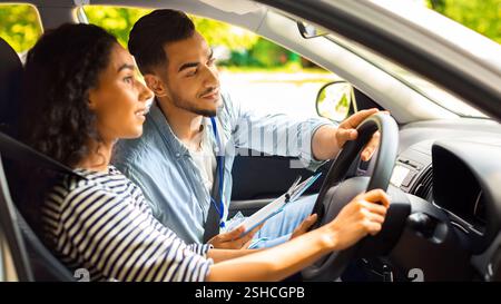Handsome arab man driving instructor holding steering wheel Stock Photo