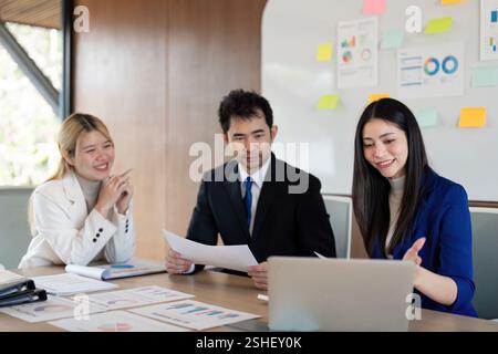 Engaged diverse business team discussing financial reports and strategies in a modern office setting. Stock Photo