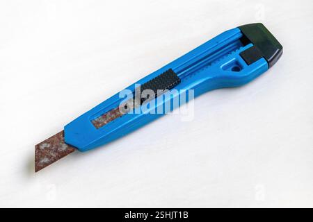 An old, rusty, blue cutter knife on a white background. Stock Photo