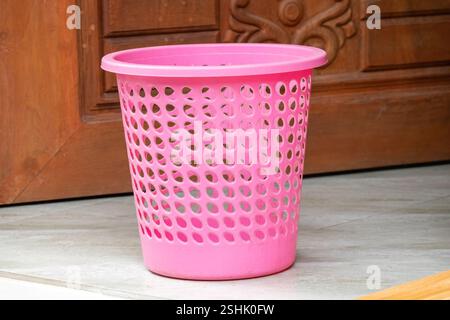 An empty plastic trash bin rested on the floor. Stock Photo