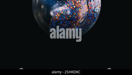 Mystical sphere. Rainbow bubble. Round shiny soap circle colorful spots on black surface. Abstract dark atmospheric background empty space. Stock Photo