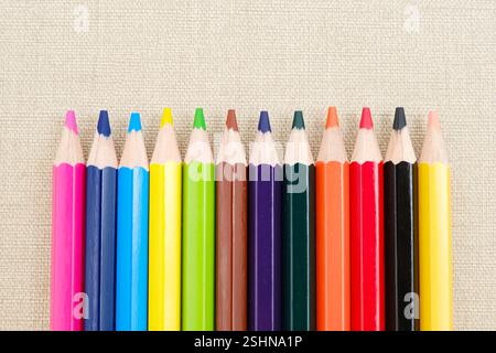 Colorful sharpened pencils are lined up on the table. Flat lay Stock Photo