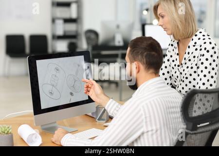 Technicians making digital engineering drawing on computer at desk in office Stock Photo