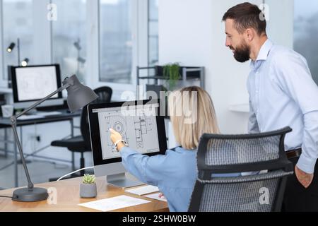Technicians making digital engineering drawing on computer at desk in office Stock Photo