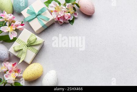 Pastel eggs and gift boxes with flowers on a light background Stock Photo