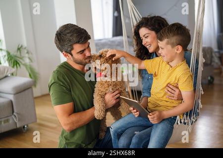 Parents with kid having fun online with application watching video cartoon or playing game on tablet Stock Photo