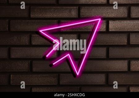 Pink neon arrow-shaped pointer on brick wall Stock Photo