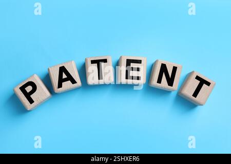 License. Word Patent made of wooden cubes with letters on light blue background, top view Stock Photo