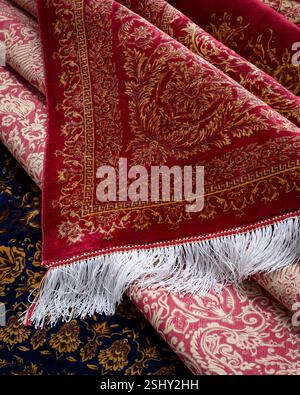 Close-up of a richly textured hand-knotted Persian carpet, revealing intricate patterns and vibrant colors Stock Photo