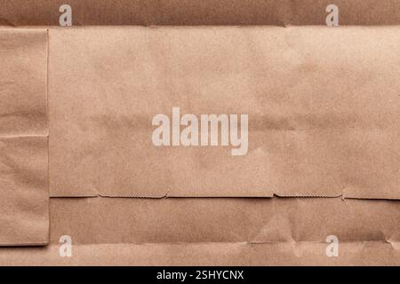 Brown kraft paper folded with seams and structured edges. Layered sustainable packaging material. Detailed creases. Close-up Stock Photo