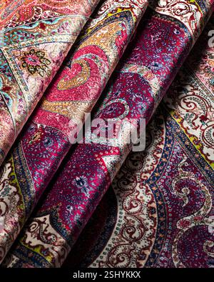 Folded Persian rug showcasing vibrant floral patterns and rich textures in a close-up studio shot, emphasizing traditional design. Stock Photo