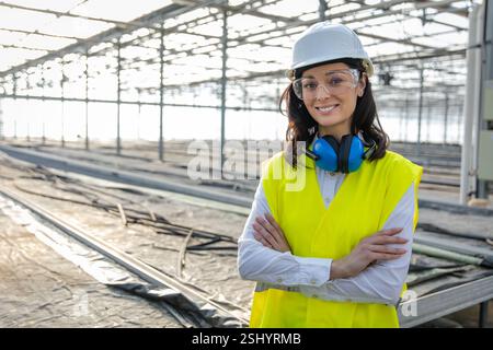 Smiling caucasian young female engineer in protective glasses Stock Photo