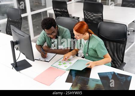 Professionals surgeon and colleague collaborating on treatment plans in hospital office Stock Photo
