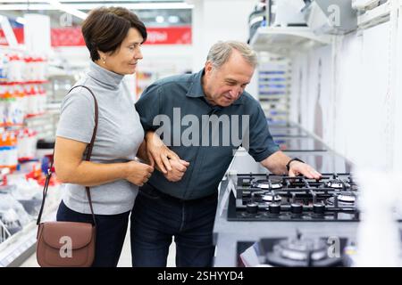 Mature couple choosing stove in home appliances department in grocery store Stock Photo