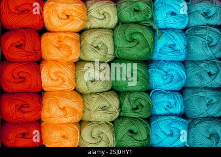 Background of colorful balls of wool threads for knitting, vibrant colors pattern, material for handmade items, hand knitting and needlework Stock Photo