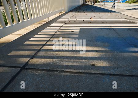 Enclosure and shadows on the ground of footpath in the city Stock Photo