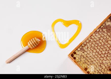 spoon with spilled honey and bee honeycomb on white background, top view, beekeeping concept Stock Photo